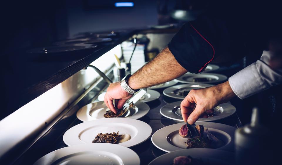 Chefs plating dishes in a professional kitchen
